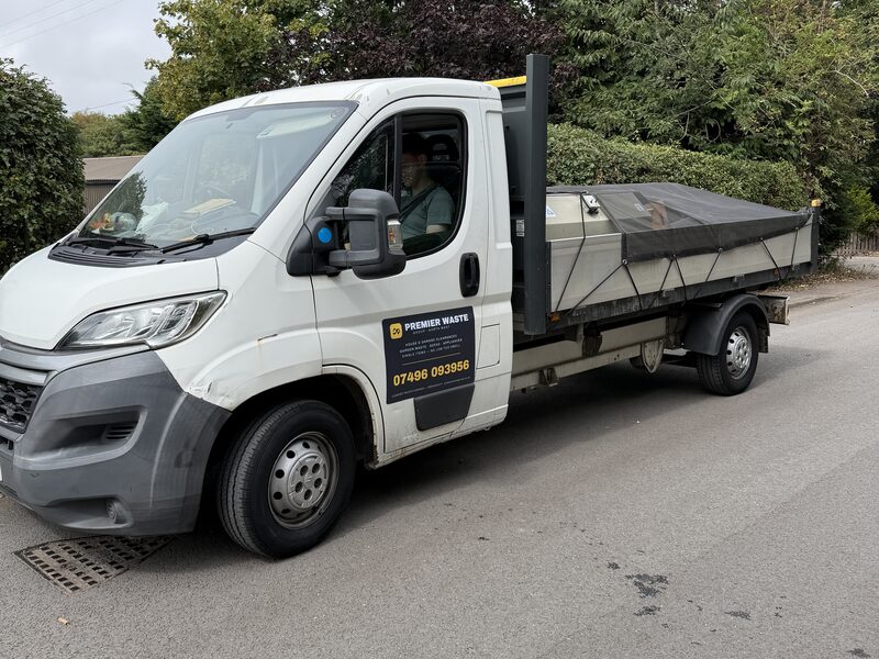 One of the Premier Waste Group team at the wheel of the flatbed truck, loaded up and out on a collection