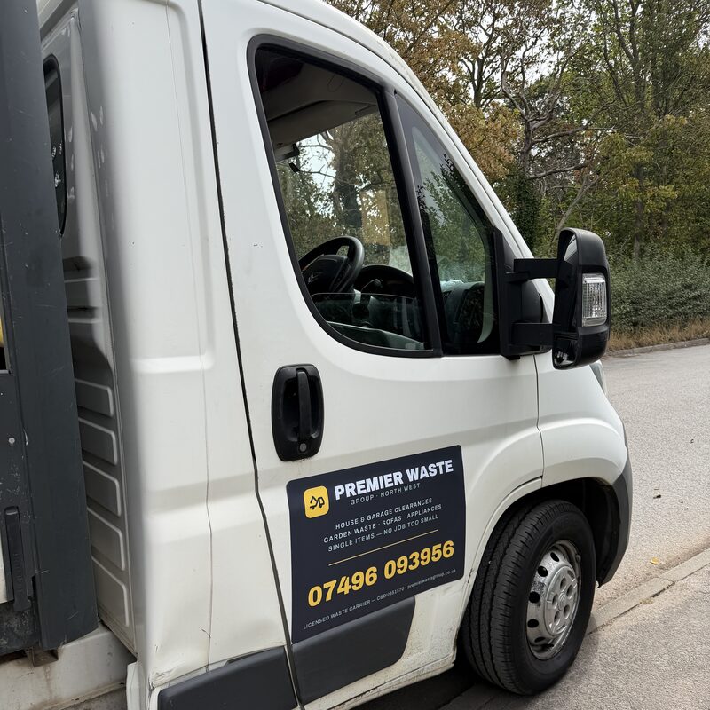 Close-up of the Premier Waste Group livery on the truck door, showing the phone number and the licensed waste carrier registration CBDU651570